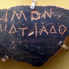 Fragment ostrakonu z greckim napisem. Widać imię "KIMON" i "MIATIAAO".