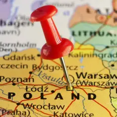 Czerwony pinezka wbita w mapę Polski, zaznaczając Warszawę. Ciekawe miejsca i ciekawostki o Polsce czekają na odkrycie!
